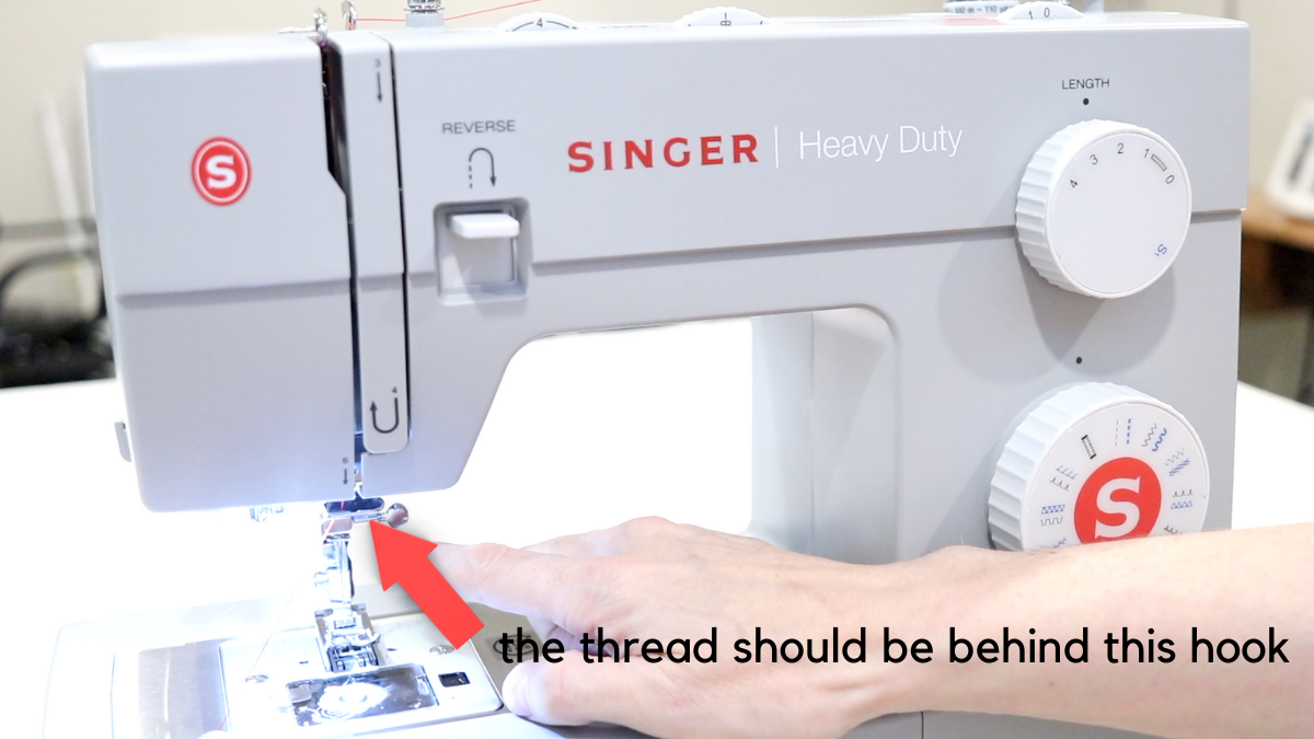 Guide number 6 on a gray singer sewing machine. Red arrow pointing to the guide for the thread